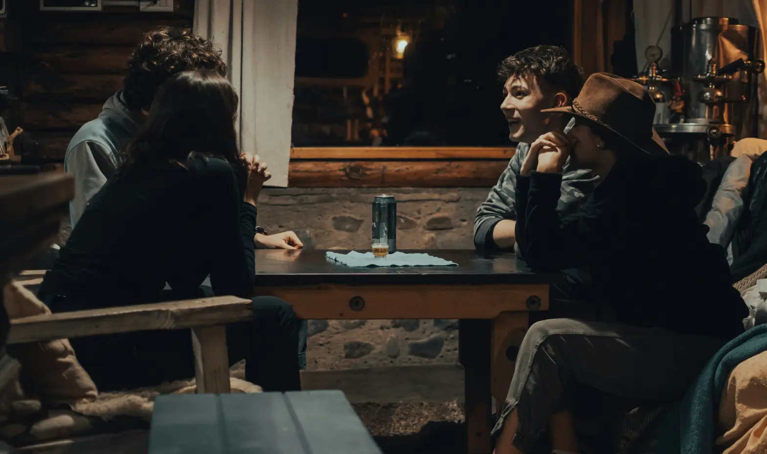 A group of four people enjoying a board game at a table, sharing smiles and engaging in friendly competition.