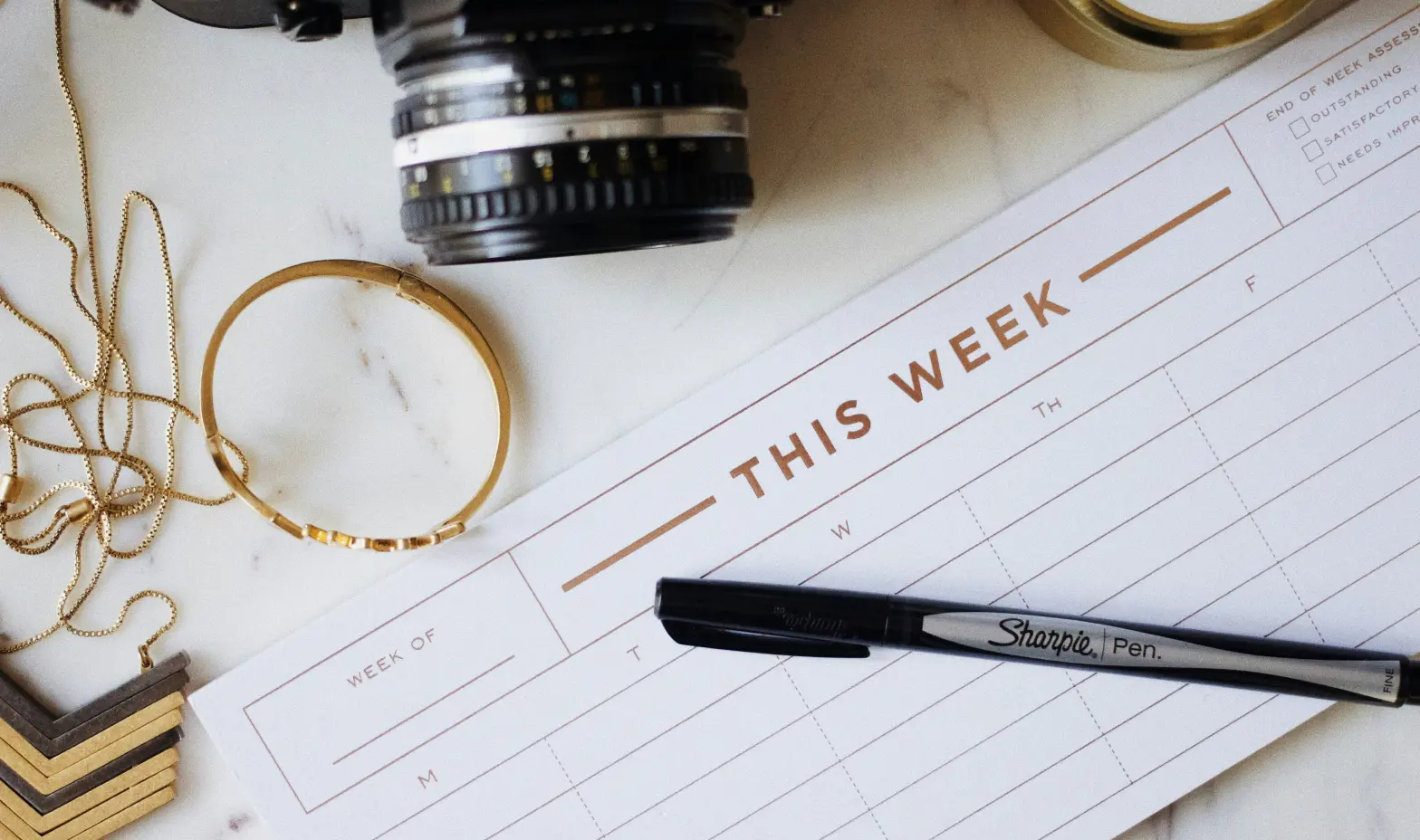 Weekly planner open on a desk, filled with colorful notes and reminders for upcoming tasks and events.