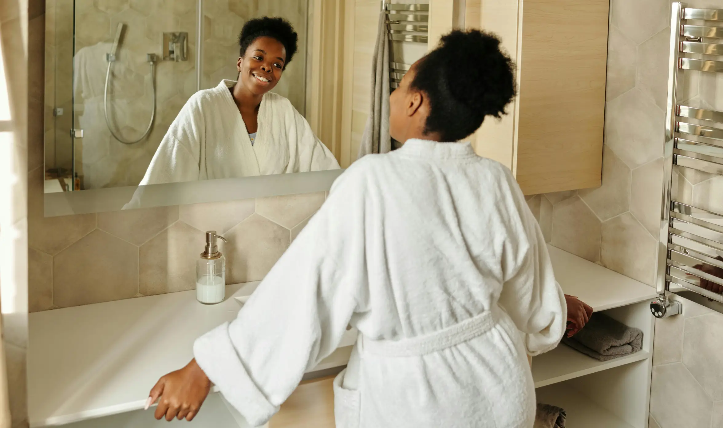 A woman standing in front of a bathroom mirror