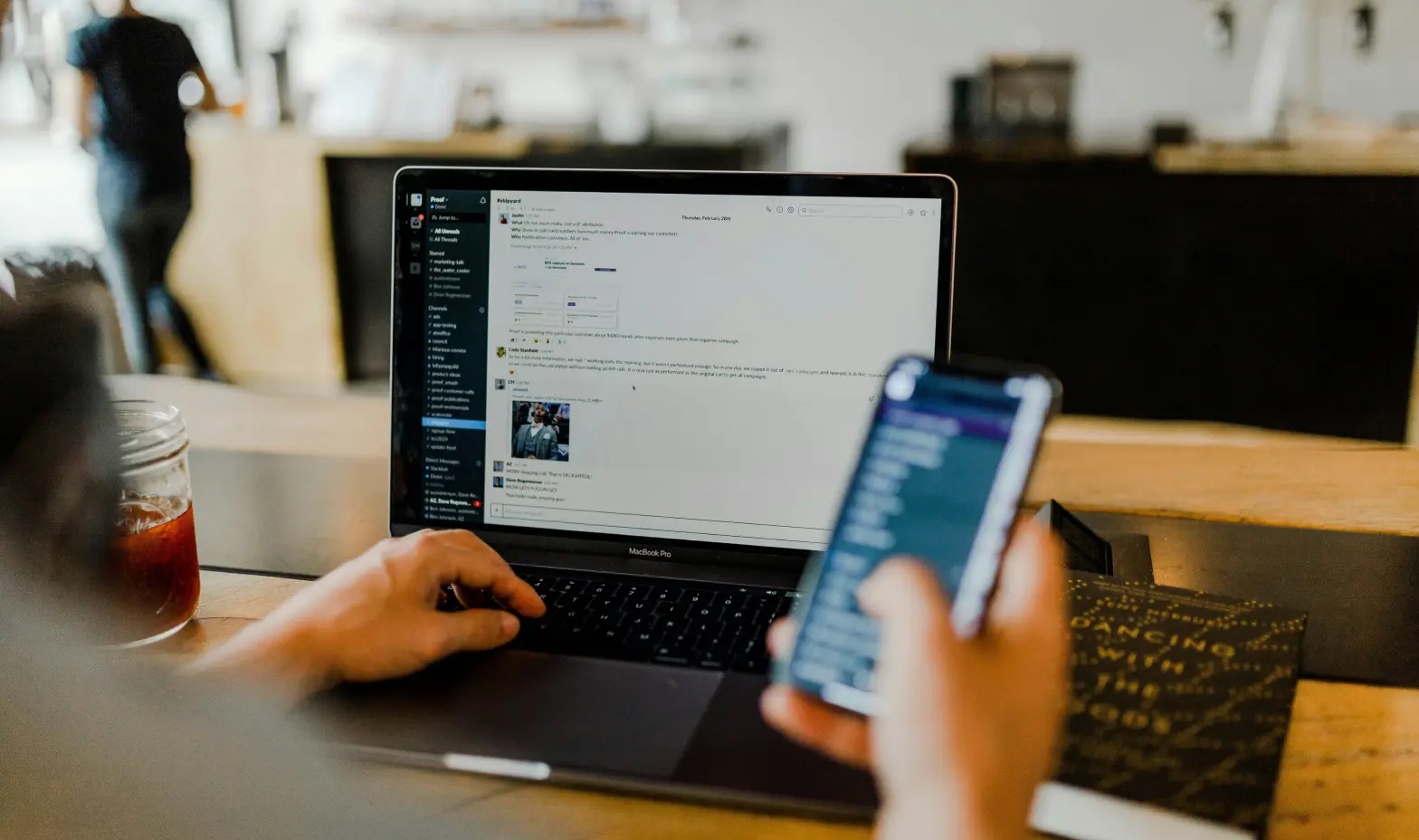 A person accessing a website on a laptop while using a smartphone for additional information.