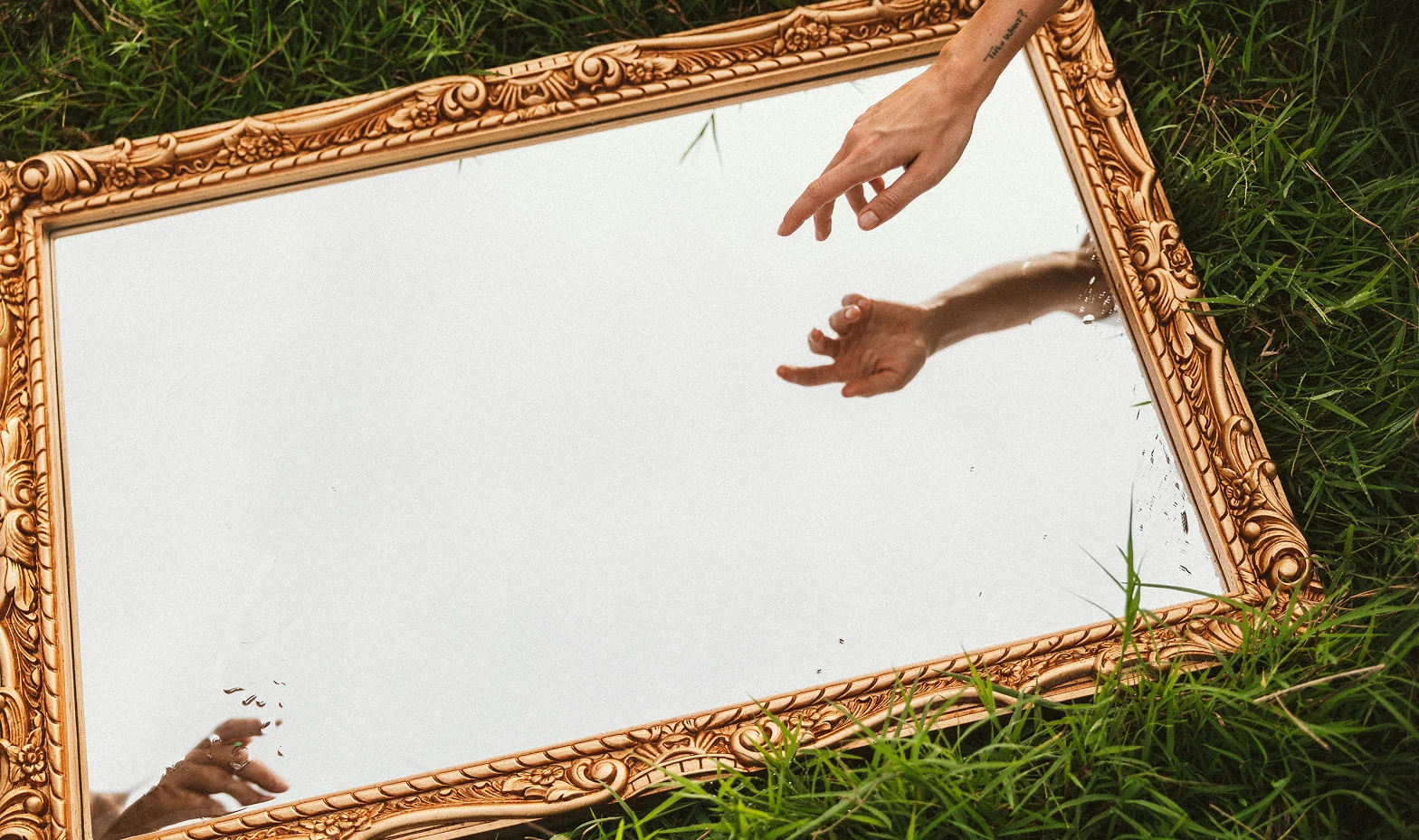 a hand touching a mirror reflection