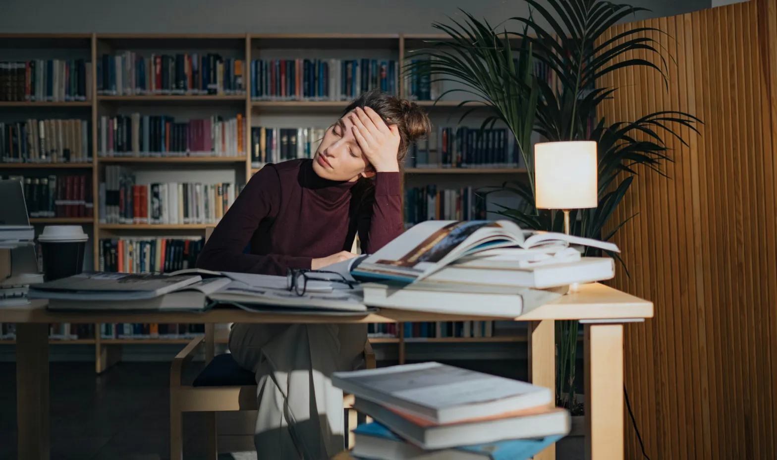 A woman sitting at a table with a lot of books