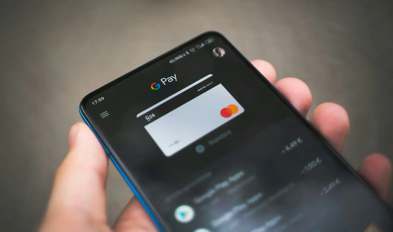 A person holding a cell phone with a pay button on the screen